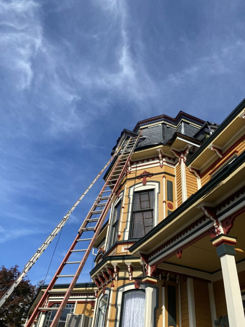 A ladder is attached to the side of an old house.