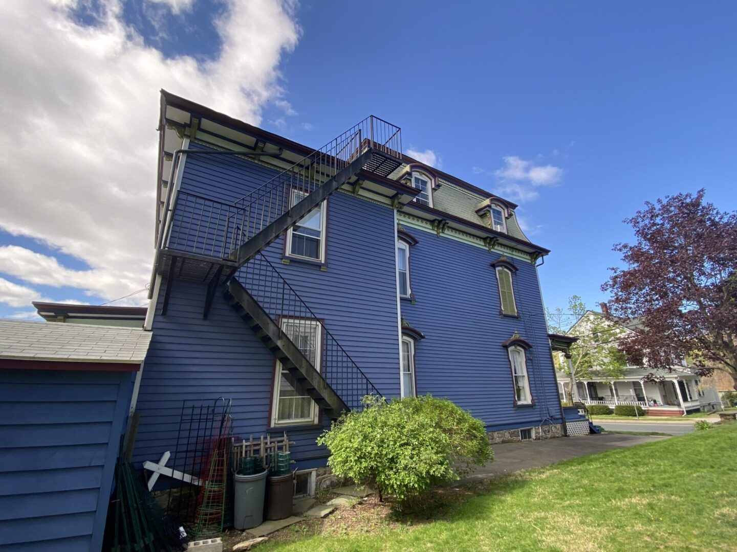 A blue building with fire escape stairs on the side.