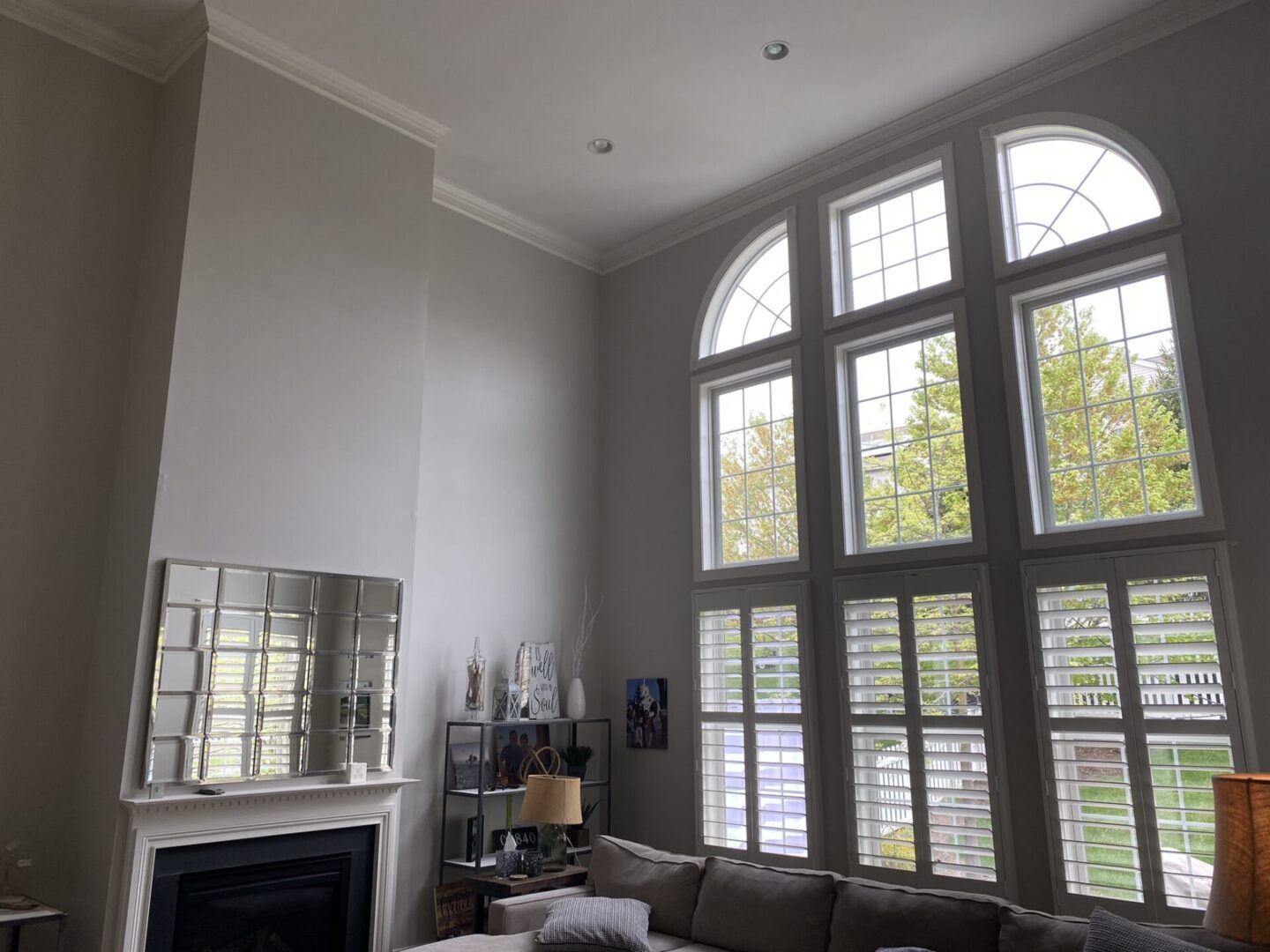 A living room with two large windows and a fireplace.